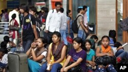 Women from India's northeastern states wait with their baggage to board trains home, at a railway station in Bangalore, India, August 16, 2012.