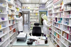 Pharmacists pick medicine from shelves in a drugstore in downtown Tehran, Iran, June 19, 2019.