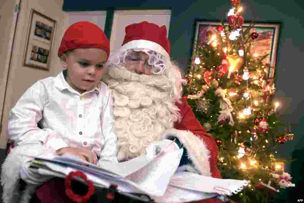 2017年12月24日，圣诞节前夕，在芬兰埃斯波，一名装扮成圣诞老人的男子把圣诞礼物带给儿童。