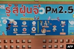 This photo taken on January 22, 2024 shows an information chart of PM2.5 air pollution at Suanlumpinee School in Bangkok. (Photo by MANAN VATSYAYANA / AFP)