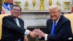 美国总统特朗普（Donald Trump）2月7日在白宫会见来访的日本首相石破茂（Shigeru Ishiba）。图为两人握手致意。