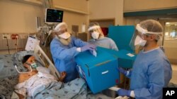 COVID-19 patient Rahamim Havura votes for Israel's parliamentary election inside an intensive care ward for coronavirus patients at Ichilov Hospital in Tel Aviv, Israel, March. 23, 2021. 