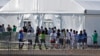 FILE - Detained migrant children from Central America line up to enter a tent at the Homestead Temporary Shelter for Unaccompanied Children in Homestead, Florida, Feb. 19, 2019. 