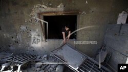 A Lebanese man removes debris from his damaged house, hit by rockets fired by Syrian rebels according to villagers, in Hermel town, northeast of Lebanon, Wednesday May 29, 2013. Shells fire from Syria regularly strike the Lebanese northeastern town of Her