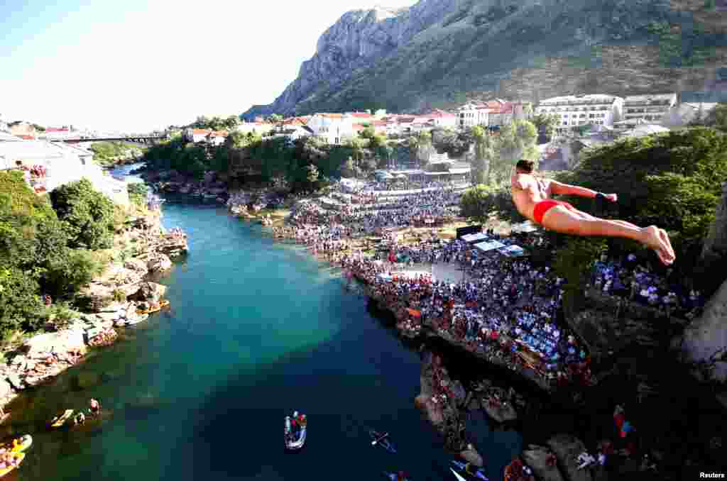 Seorang pria tampak melompat dari jembatan tua pada Kompetisi Melompat Tradisional ke-450 di Mostar, Bosnia dan Herzegovina.