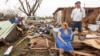 FILE - Raella Faulkner, at left, and Bobby McElroy survey what's left of their home, April 28, 2014, after a tornado struck the town of Vilonia, Arkansas. 