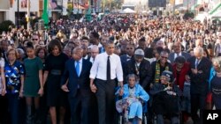 奥巴马一家以及乔治亚州选出的一位联邦众议员等人和民众一起游行，纪念从塞尔玛到蒙哥马利的两次争取投票权的游行示威50周年
