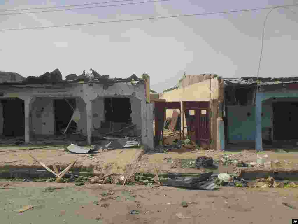 Heavily damaged buildings and bloodstains on the street can be seen following a suicide bomb explosion at a World Cup viewing center, Damaturu, Nigeria, June 18, 2014.