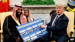 FILE - President Donald Trump shows a chart highlighting arms sales to Saudi Arabia during a meeting with Saudi Crown Prince Mohammed bin Salman in the Oval Office of the White House, Tuesday, March 20, 2018, in Washington.