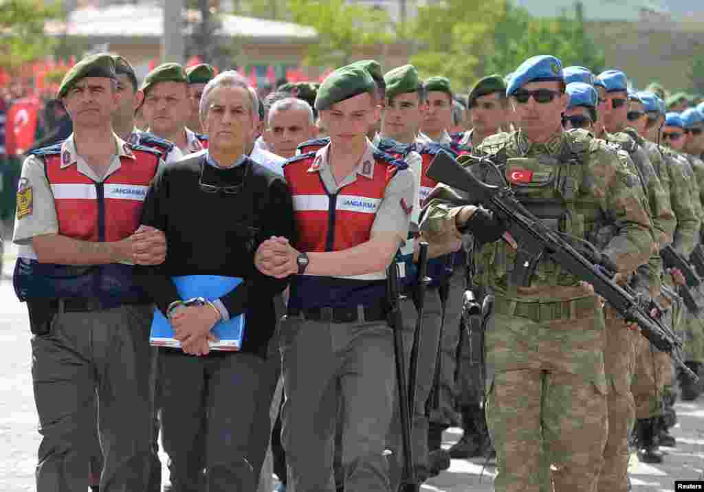 Akin Ozturk, mantan panglima Angkatan Udara Turki yang dituduh berada di belakang kudeta militer yang gagal, dikawal pada saat tiba di pengadilan di Ankara.