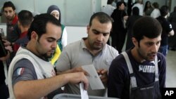 Men vote at a polling station for parliamentary elections in Damascus, Syria, May 7, 2012.
