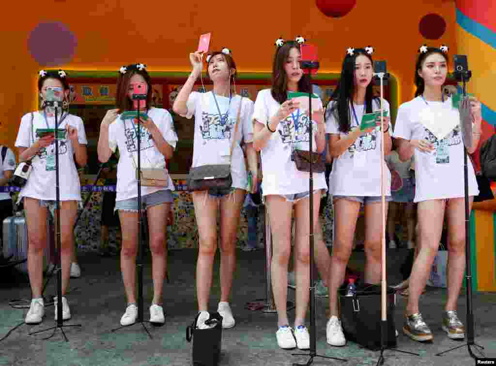 网络直播者在中国广州长隆野生动物园直播世界上唯一的大熊猫三胞胎萌萌、帅帅和酷酷的4岁生日庆生会（2018年7月29日）。