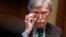 FILE - National Security Adviser John Bolton adjusts his glasses during a meeting in the Oval Office at the White House in Washington, April 2, 2019.