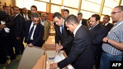 Perdana Menteri Tunisia Mehdi Jomaa (tengah) dan presiden badan pemilu yang baru dipilih Mohamed Chafik Sarsar (kiri) memeriksa kotak suara dan kertas suara sebelum didistribusikan ke TPS-TPS di Nabeul, 25 Oktober 2014. 