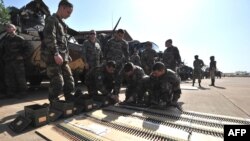 法国士兵1月16日在部署之前，在巴马科空军基地准备他们的弹药
