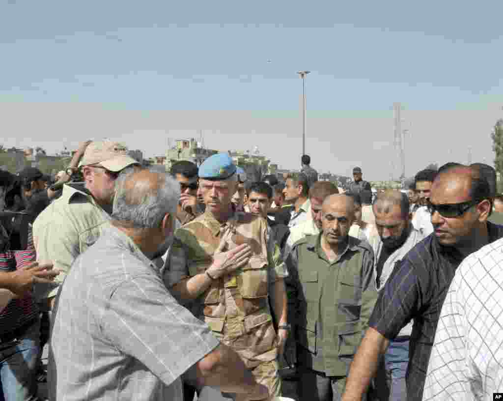 The chief of the U.N. Supervision Mission to Syria, Norwegian Major General Robert Mood (C), and his team inspect the site of an explosion in Damascus.