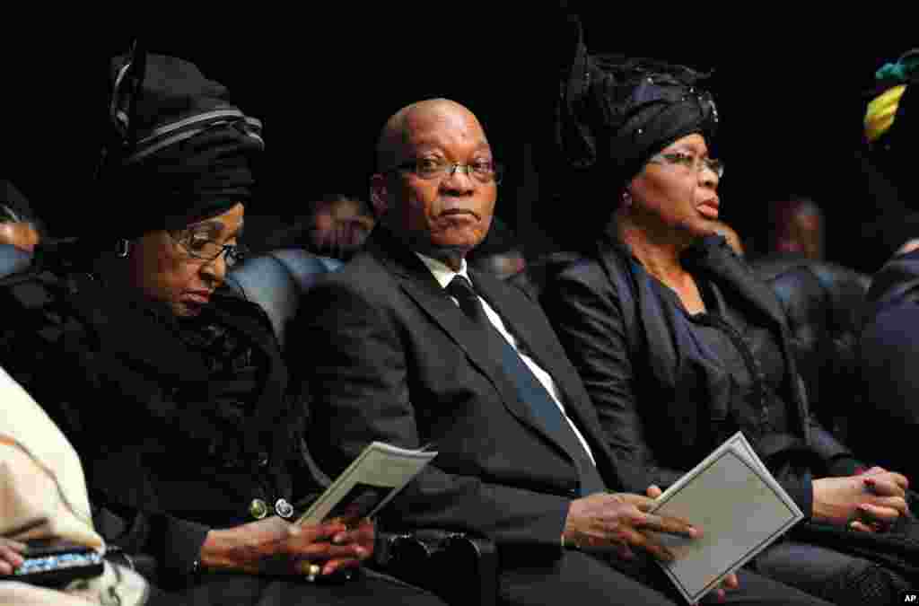 Presiden Afrika Selatan Jacob Zuma duduk di antara Winnie Madikizela-Mandela, mantan istri Nelson Mandela, dan janda Nelson Mandela, Graca Machel, kanan, menghadiri upacara pemakaman mantan presiden di Qunu.