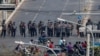 Police stand in formation blocking a main road in Mandalay, Myanmar, Feb. 27, 2021. 