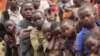 M23 rebel fighters watch the venue of a news conference by political leader Jean-Marie Runiga, in Bunagana, eastern DRC, in north Kivu province, July 21, 2012.