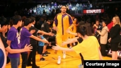 지난 14일 미국 프로농구단 LA레이커스 경기 시작에 앞서, 탈북 청소년들이 다른 팬들과 함께 출선 선수들을 맞고 있다. 오멜버른 법률회사 사진 제공.