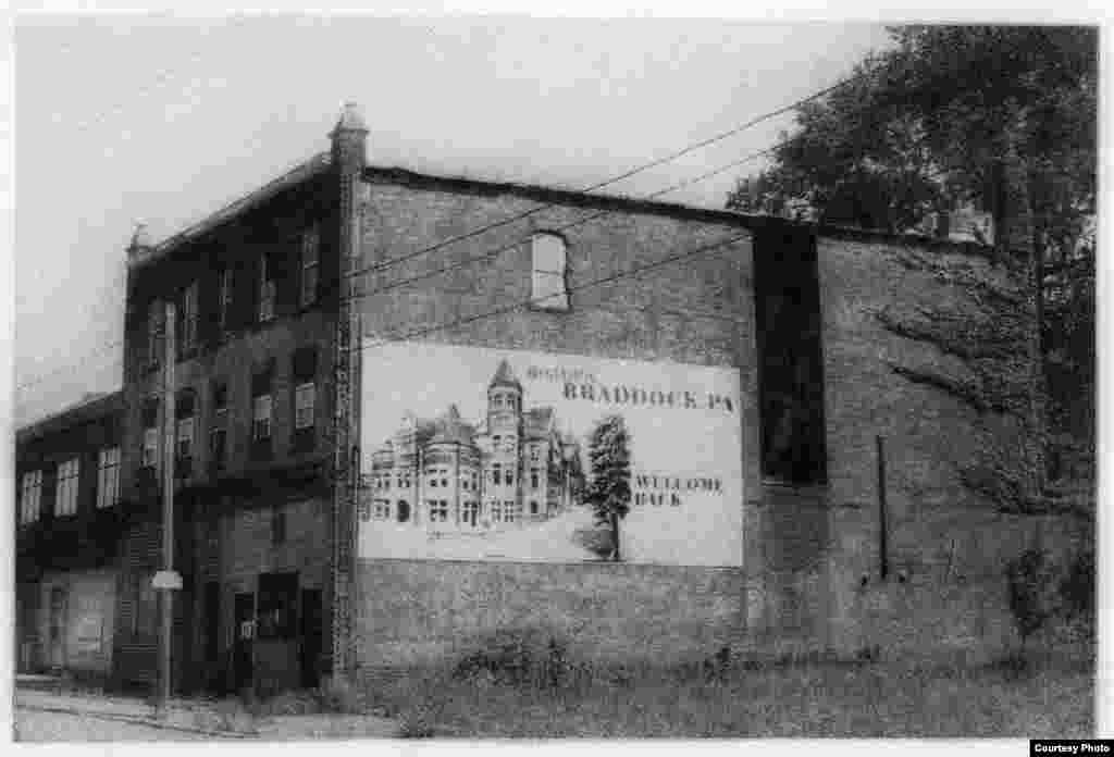 This building, with a banner welcoming people to historic Braddock, Pennsylvania, has spraypaint on the front door indicating it is scheduled to be torn down, which it was after this image was taken. (George L. Smyth)