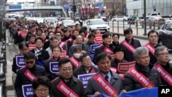 Doctors march toward the presidential office during a rally against the government's medical policy in Seoul, South Korea, Sunday, Feb. 25, 2024. 