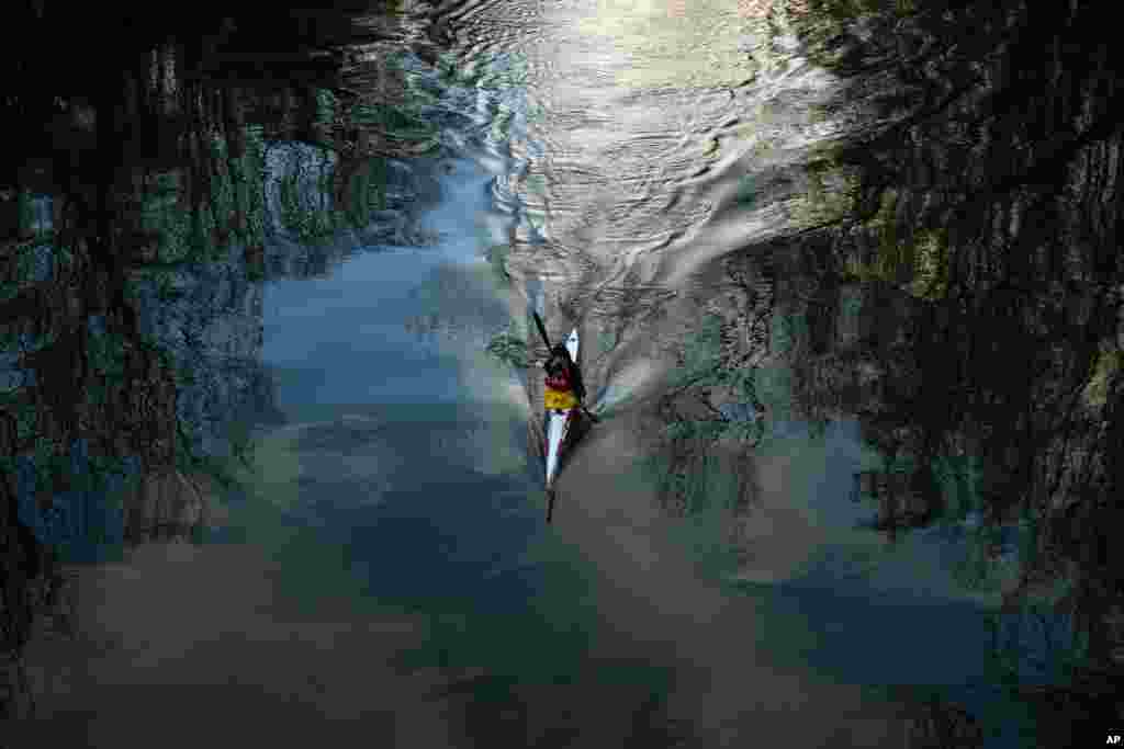Winter trees and a kayaker are reflected in the Arga River in Pamplona, Spain, March 6, 2018.