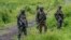 FILE - M23 rebels stand with their weapons in Kibumba, in the eastern of Democratic Republic of Congo, Dec. 23, 2022.