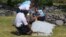 French gendarmes and police inspect a large piece of plane debris that was found on the beach in Saint-Andre, on Reunion Island in the Indian Ocean, July 29, 2015.
