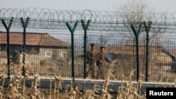 지난 2017년 3월 중국 단둥에서 바라본 북한 신의주에서 군인들이 철책을 순찰하고 있다.