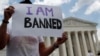 FILE - Mehrad Ansari of Iran holds a sign outside of the U.S. Supreme Court after U.S. President Trump's travel ban was upheld in Washington, June 26, 2018. 