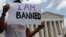 FILE - Mehrad Ansari of Iran holds a sign outside of the U.S. Supreme Court after U.S. President Trump's travel ban was upheld in Washington, June 26, 2018. 