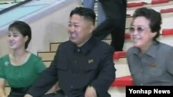 능라인민유원지 준공식 참석해 김정은 국방위원회 제 1위원장과 그의 부인 리설주와 곱등어(돌고래)관에서 돌고래의 묘기를 구경하는 김경희(사진 오른쪽) 노동당 비서 