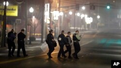 지난 12일, 퍼거슨 지역 경찰관들이 동료 두 명이 총격당한 현장을 조사하고 있다. 