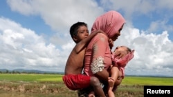 一位缅甸罗兴亚难民妈妈携儿带女越境进入孟加拉国。（2017年10月9日）