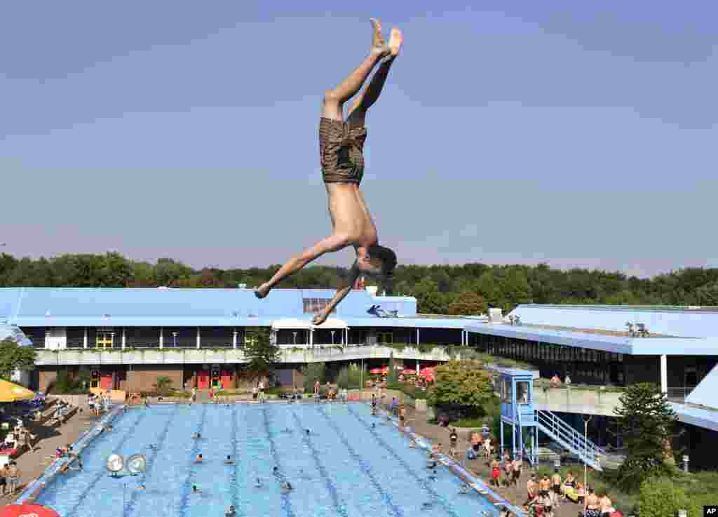 កុមារ​ម្នាក់​លោត​ចូល​ក្នុង​អាងទឹក​សាធារណៈក្នុង​ថ្ងៃដ៏​ក្តៅ​នៅ​ទីក្រុង Gelsenkirchen ប្រទេស​អាល្លឺម៉ង់។