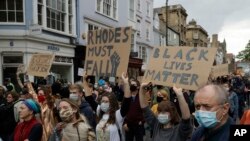 Protesters urge the removal of a statue of Victorian imperialist Cecil Rhodes in Oxford, England, June 9, 2020. More statues of imperialist figures could be removed following the toppling of a monument to slave trader Edward Colston in Bristol.
