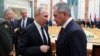 Russian President Vladimir Putin, foreground left, speaks to Russian Defense Minister Sergei Shoigu during the Collective Security Council of the Collective Security Treaty Organization (CSTO) summit in Minsk, Belarus, Nov. 30, 2017. 