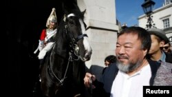 FILE - Artist Ai Weiwei passes a member of the Household Cavalry on duty outside Horse Guards Parade as he walks through central London, Sept. 17, 2015.