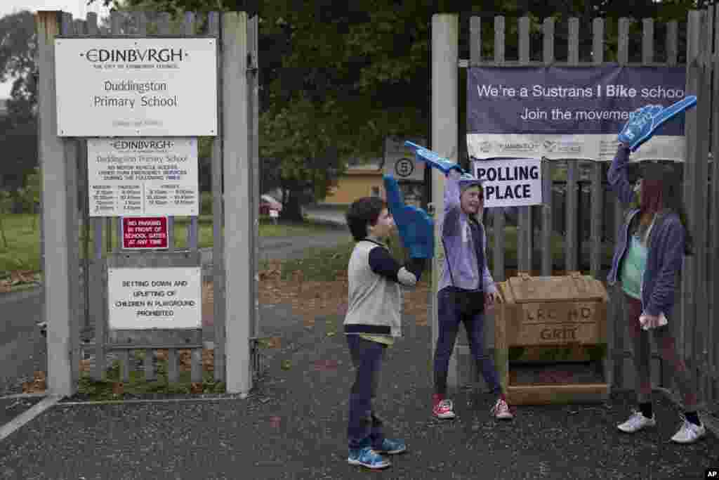 Anak-anak bermain di luar tempat pemungutan suara di Edinburgh, Skotlandia (18/9).&nbsp;(AP/Matt Dunham) 