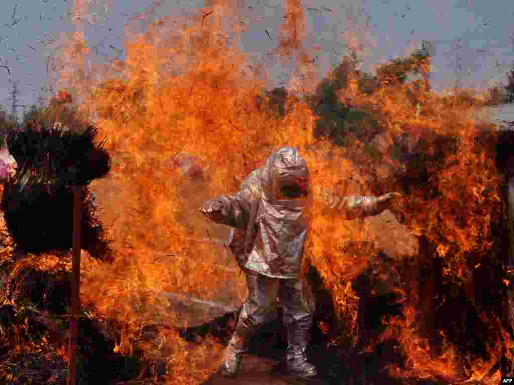 Seorang pemadam kebakaran India melakukan demonstrasi keahlian mereka dalam latihan menangani kebakaran di kota Bhubaneswar.