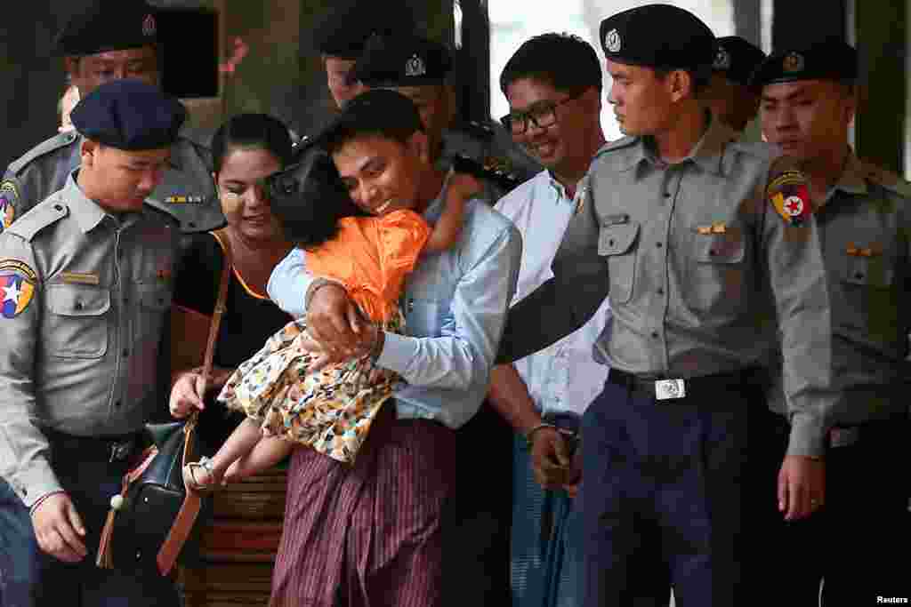 លោក Kyaw Soe Oo អ្នកកាសែត​ Reuters ដែល​ត្រូវ​បាន​ចាប់​ខ្លួន អោប​​កូន​ស្រី​របស់​ខ្លួន​ខណ​ដែល​លោក​ត្រូវ​ប៉ូលិស​បញ្ជូន​មក​តុលាការ​​នៅ​ក្នុង​ទីក្រុង​រ៉ង់ហ្គូន​ប្រទេស​មីយ៉ាន់ម៉ា។