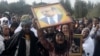 A woman wails while lifting a portrait of the late Ethiopian Prime Minsiter Meles Zenawi as she waits for the arrival of his remains in the capital Addis Ababa, August 21, 2012. 
