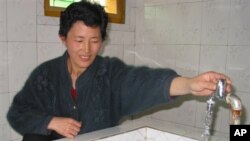 지난 2005년 북한 평양 인근의 한 농장에서 북한 주민이 외부 지원으로 지어진 수도시설을 이용하고 있다. (자료사진)