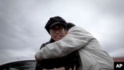 9일 화이러우 법원 앞에서 울고 있는 류샤를 친척이 감싸고 있다