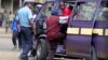 A September 2006 file photo shows a Kenyan policeman boarding a minibus after the vehicle was stopped for a traffic offence in the capital Nairobi.