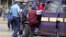 A September 2006 file photo shows a Kenyan policeman boarding a minibus after the vehicle was stopped for a traffic offence in the capital Nairobi.