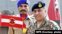 Former Lieutenant General Faiz Hamid, right, shown here in an undated photo provided by Pakistan's Inter-Services Public Relations, was charged with several criminal offenses, the Pakistani military announced on Dec. 10, 2024.