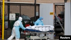 Ma'aikatan lafiya dauke da gawar wani da cutar coronavirus ta halaka a birnin New York da ke Amurka. REUT.