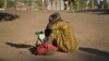 A South Sudanese refugee woman sits with her child at a refugee collection center in Palorinya, Uganda, Feb. 16, 2017.